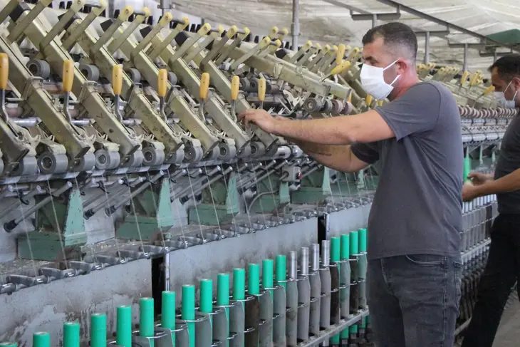 İplik eğirme makinesinin başında çalışan işçi